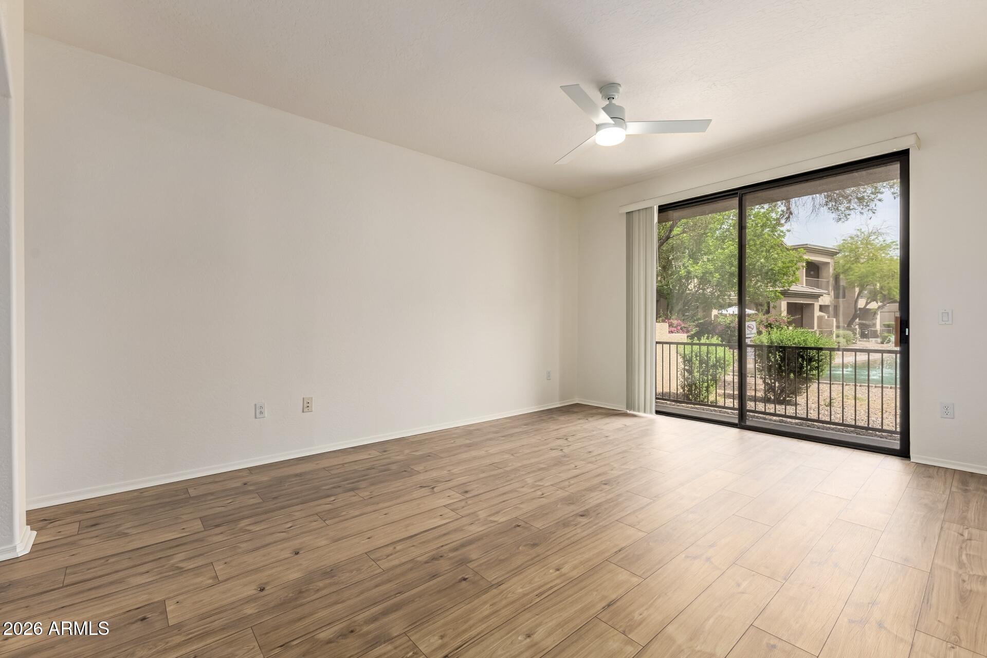 705 West Queen Creek Road, Unit 1167 Chandler, AZ 85248 - Photo 15 of 31 an empty room with wooden floor and windows