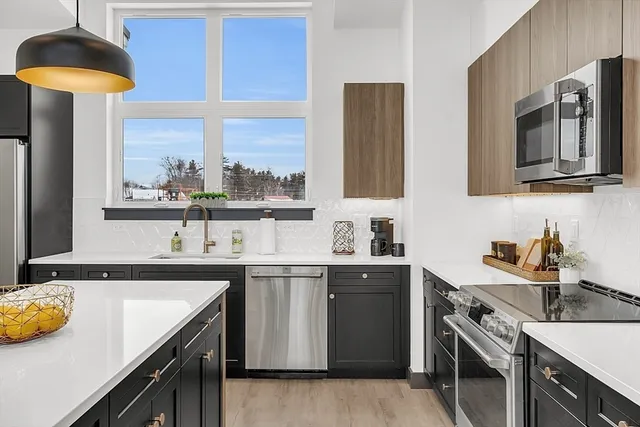 a kitchen with a sink a stove and cabinets