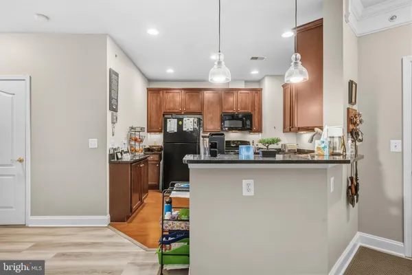 a kitchen with stainless steel appliances kitchen island granite countertop a refrigerator and a sink