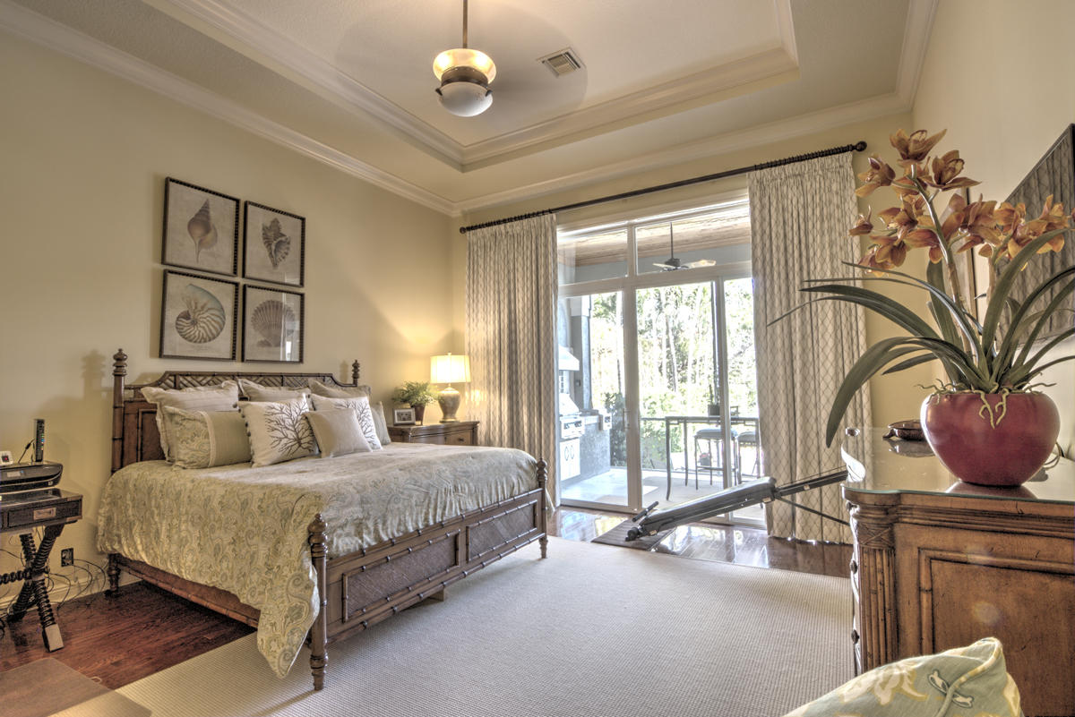 17106 Bay Street Jupiter, FL 33477 - Photo 13 of 52 a bedroom with a large bed and a chandelier