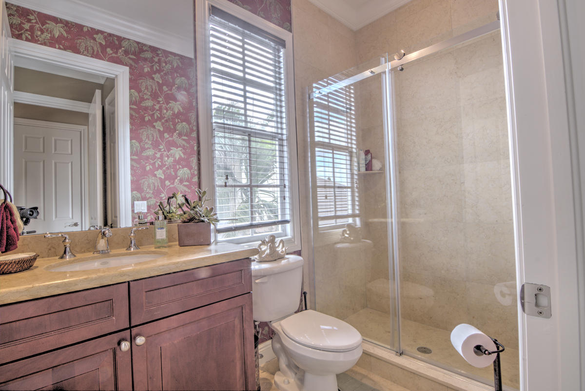 17106 Bay Street Jupiter, FL 33477 - Photo 21 of 52 a bathroom with a sink toilet a mirror and shower