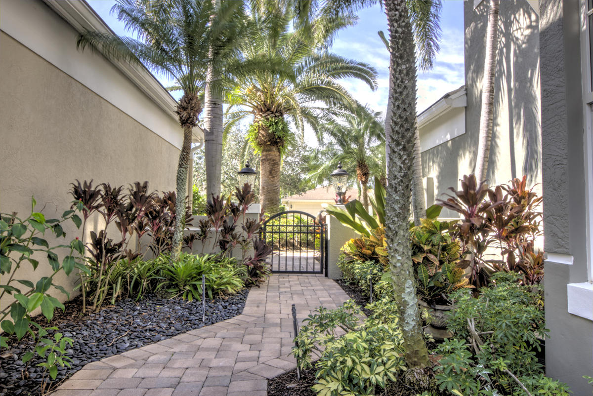 17106 Bay Street Jupiter, FL 33477 - Photo 36 of 52 a front view of a house with a garden