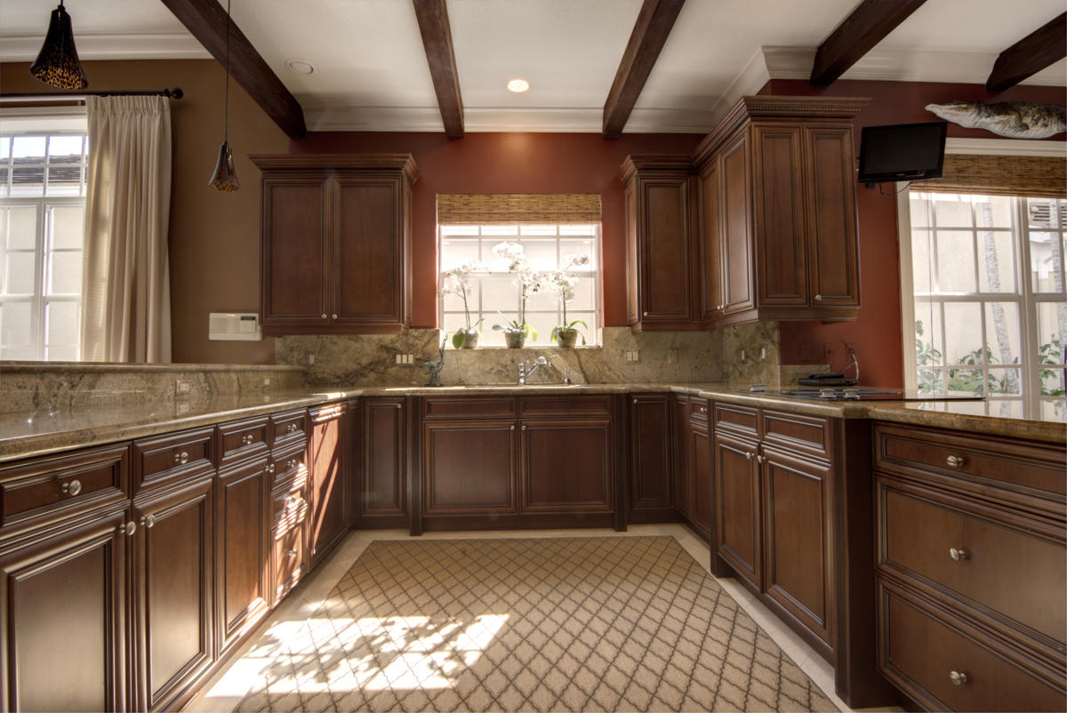 17106 Bay Street Jupiter, FL 33477 - Photo 6 of 52 a kitchen with granite countertop wooden cabinets a sink and a window
