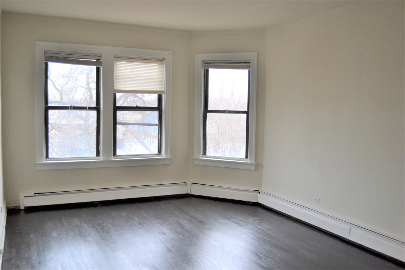 2948 West Nelson Street, Unit 3 Chicago, IL 60618 - Photo 2 of 14 an empty room with wooden floor and windows