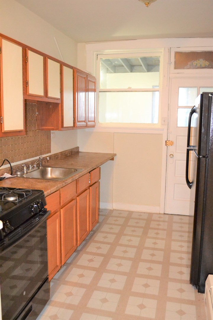 2948 West Nelson Street, Unit 3 Chicago, IL 60618 - Photo 6 of 14 a kitchen with a sink a refrigerator and window