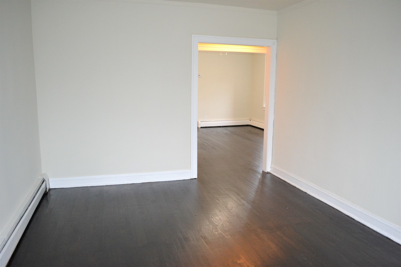 2948 West Nelson Street, Unit 3 Chicago, IL 60618 - Photo 8 of 14 an empty room with wooden floor and windows