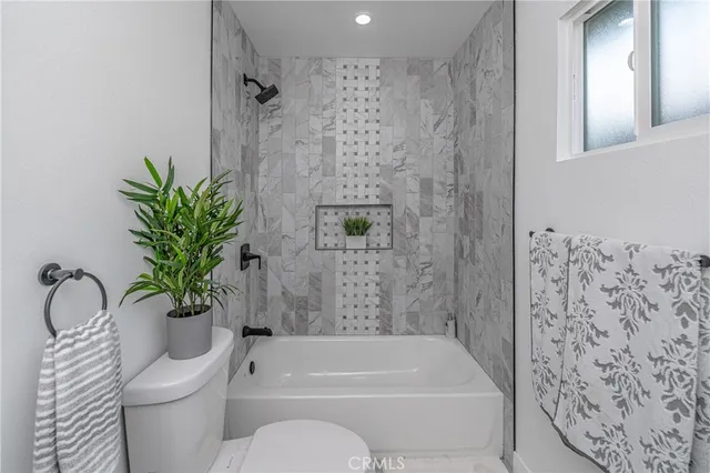 a white toilet sitting next to a bath tub