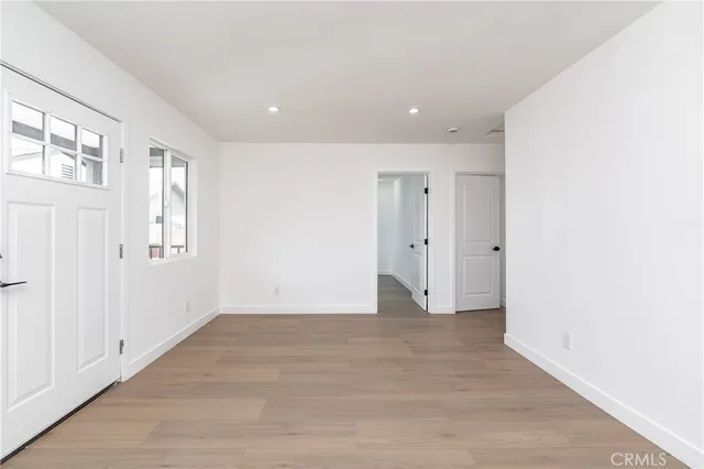 a view of an empty room with wooden floor