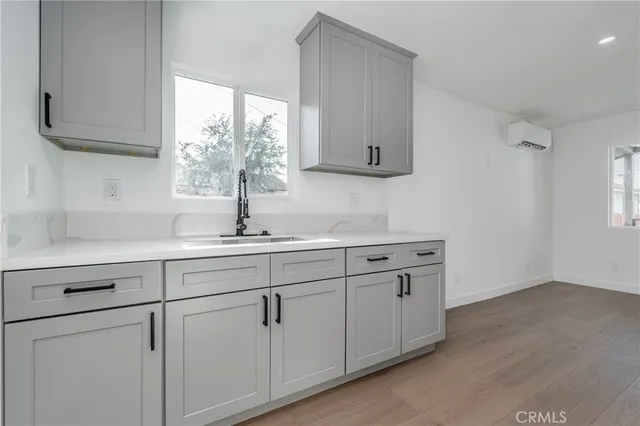 a kitchen with white cabinets and a window