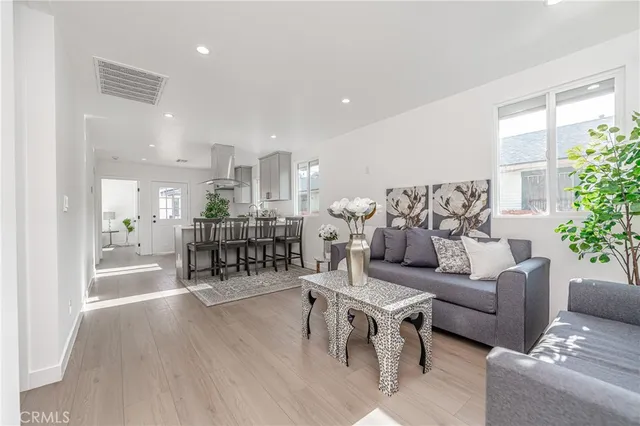 a living room with furniture and a table with wooden floor