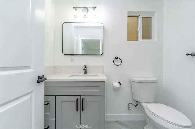 a bathroom with a toilet sink vanity and mirror