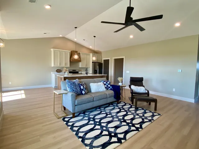 a kitchen with stainless steel appliances a sink a refrigerator a center island a stove and cabinets