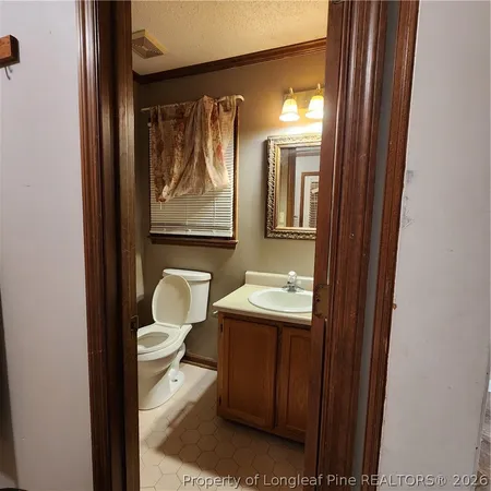 a bathroom with a toilet sink a mirror and a shower