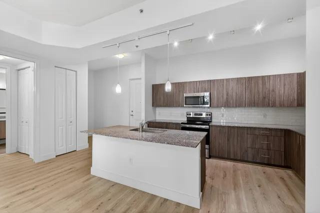 a kitchen with granite countertop wooden cabinets and stainless steel appliances