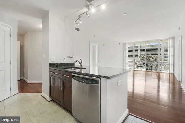 a kitchen with granite countertop wooden cabinets and stainless steel appliances