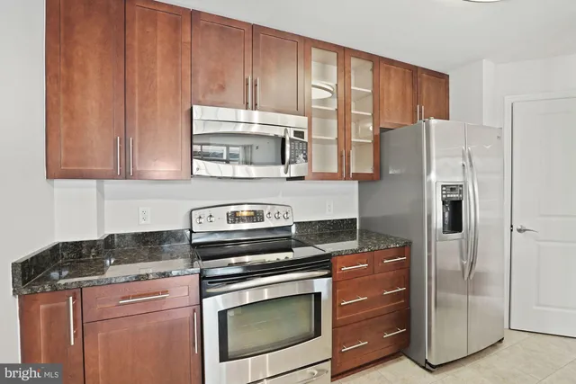 a kitchen with stainless steel appliances granite countertop a sink a stove and a refrigerator