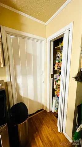 a view of a bedroom with wooden floor and furniture