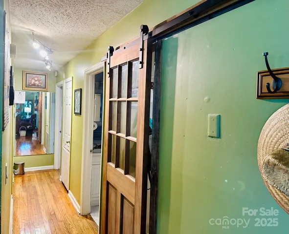 a view of a hallway with wooden floor and staircase