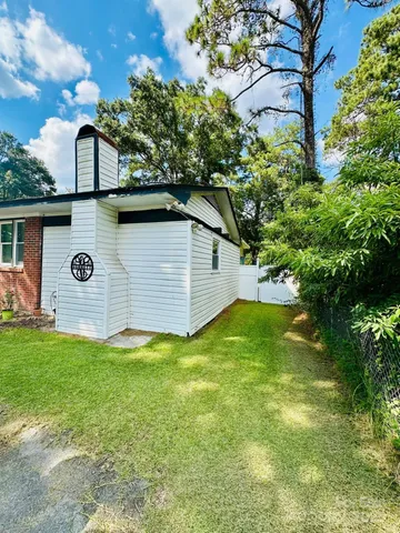 a view of a backyard with potted plants and large tree
