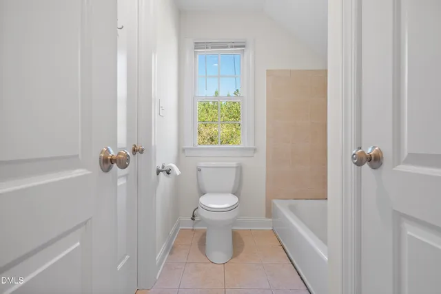 a white toilet sitting next to a white tub