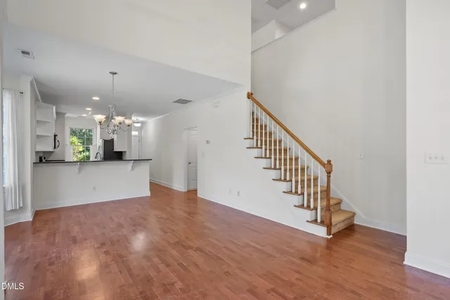 a view of a hallway with wooden floor and stairs