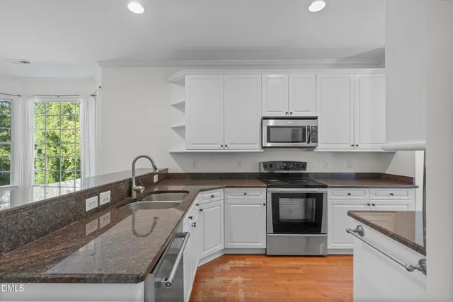 a kitchen with stainless steel appliances granite countertop a sink stove and microwave