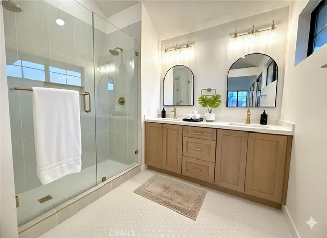 a bathroom with a double vanity sink mirror and shower