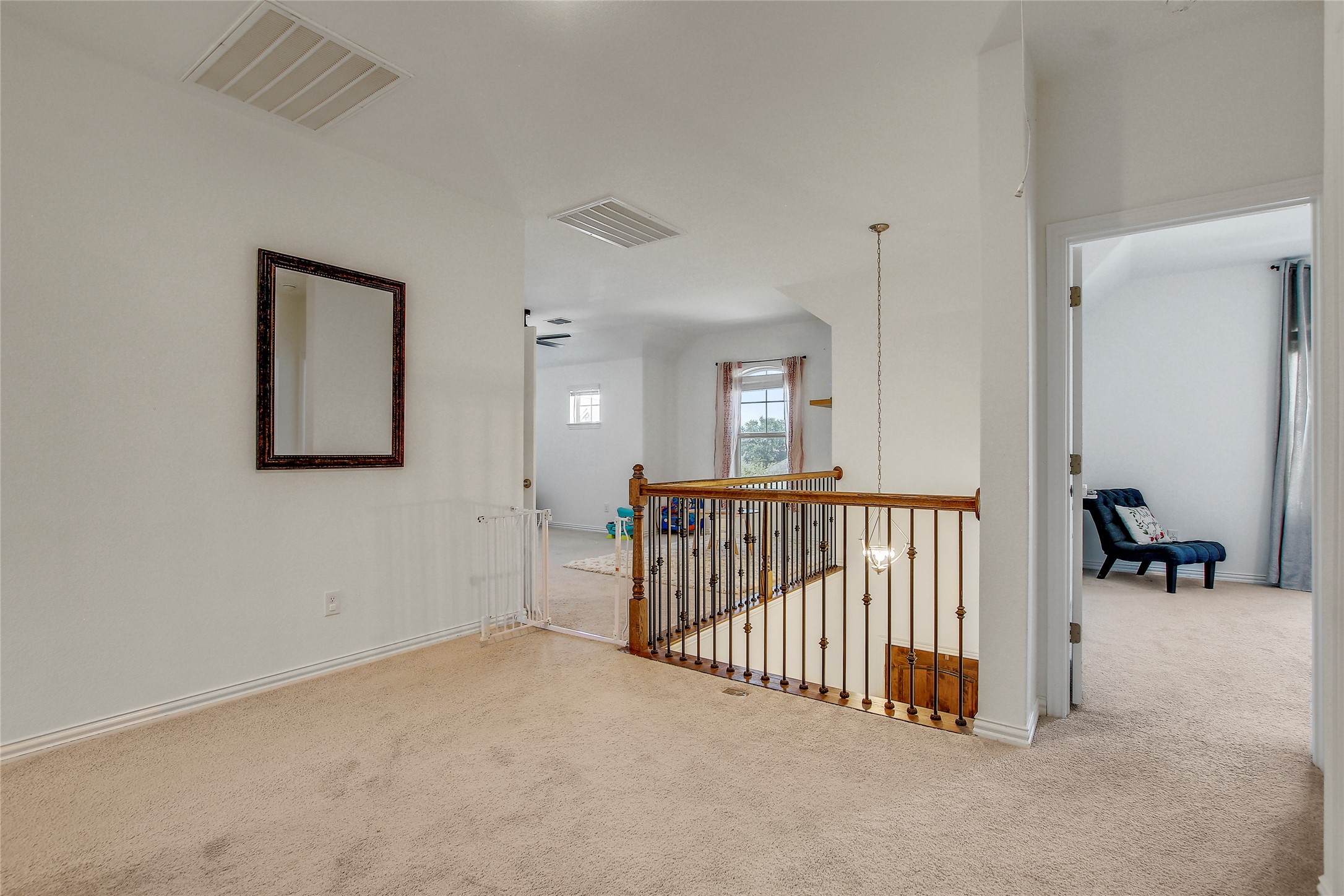 104 Millbend Road Georgetown, TX 78633 - Photo 23 of 40 A naturally illuminated upper-level landing features light carpeting and a detailed wooden banister.