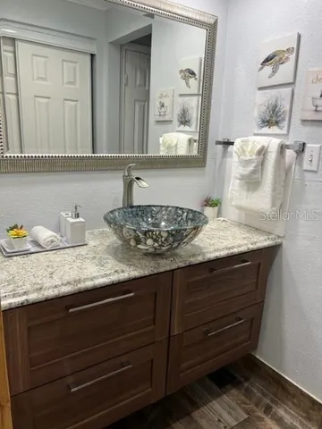 a bathroom with a granite countertop sink and a mirror