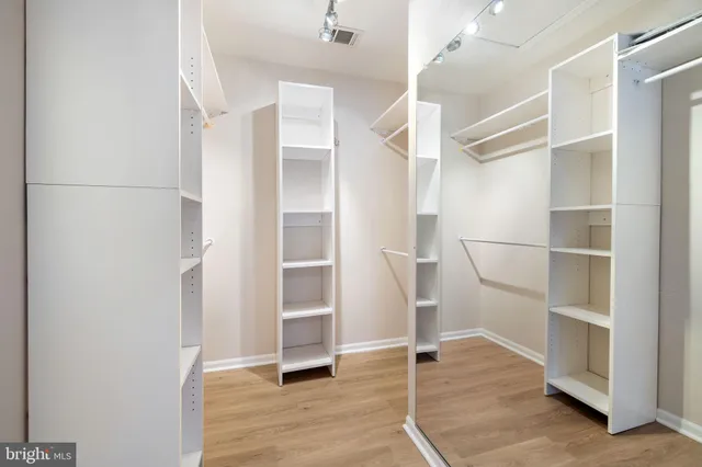 a view of walk in closet with empty racks