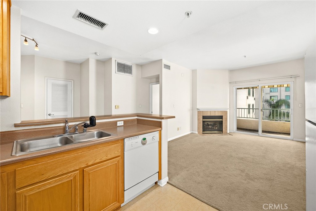 155 North Raymond Avenue Pasadena, CA 91103 - Photo 38 of 56 a view of a kitchen with granite countertop a sink and dishwasher with a fireplace