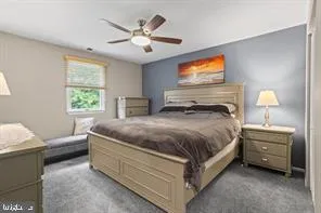 a spacious bedroom with a bed a chandelier and a couch
