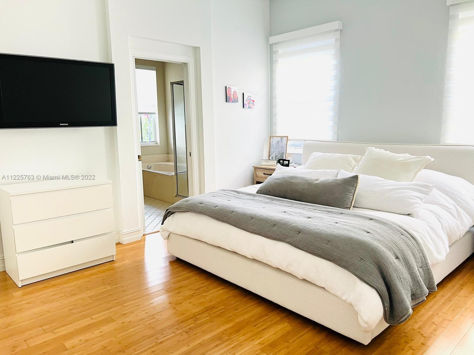 862 Tulip Circle Weston, FL 33327 - Photo 13 of 29 a bedroom with a bed and a flat screen tv