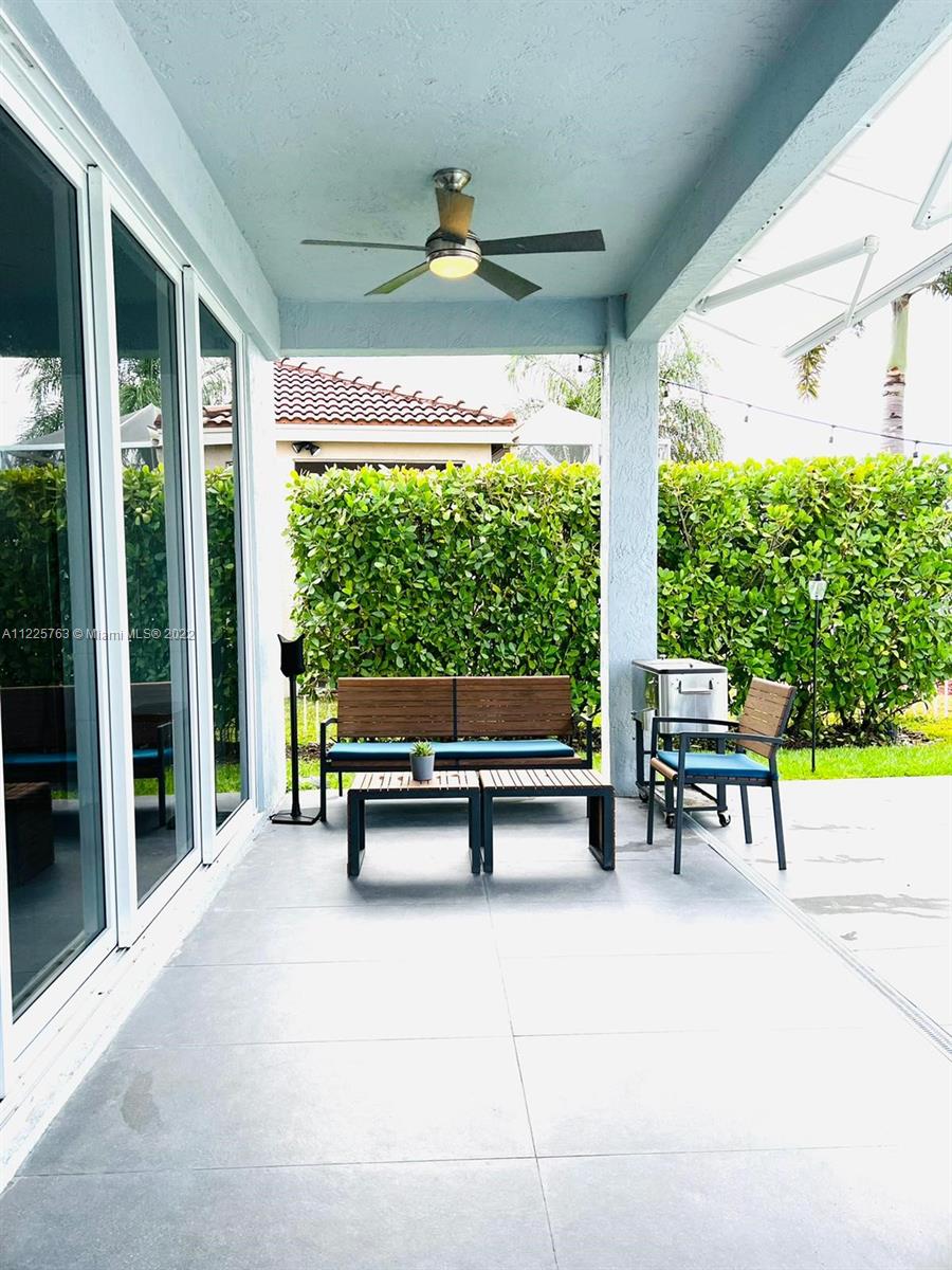 862 Tulip Circle Weston, FL 33327 - Photo 24 of 29 a view of a porch with chairs and backyard with a floor to ceiling window