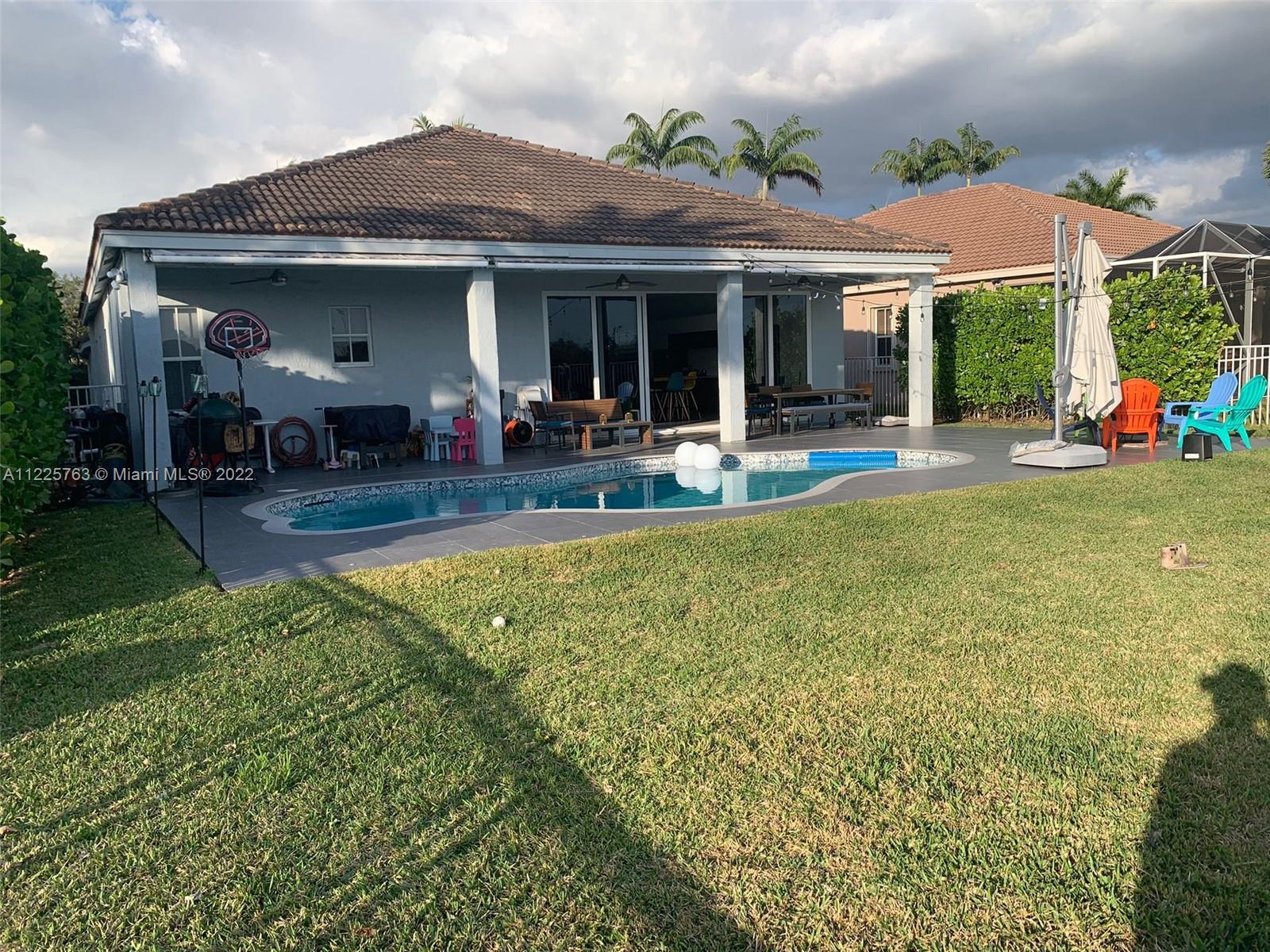 862 Tulip Circle Weston, FL 33327 - Photo 28 of 29 a view of an house with swimming pool and chairs