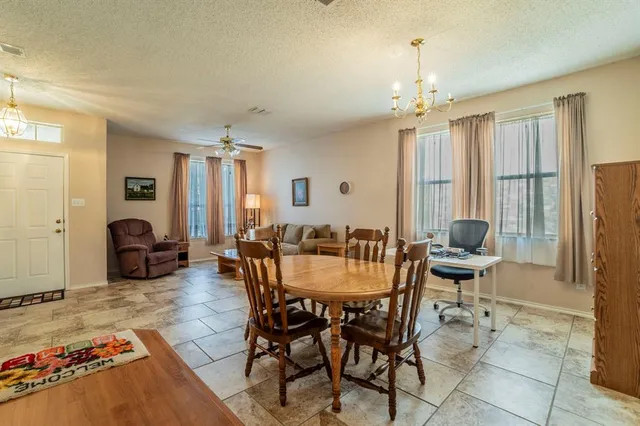 a view of a dining room with furniture and a chandelier