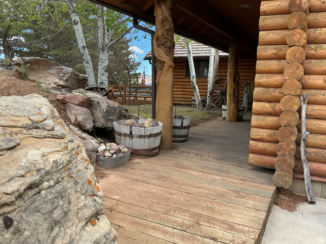 550 State Line Road Manila, UT 84046 - Photo 35 of 41 Log home exterior featuring a covered porch with plank flooring and natural wood structural elements