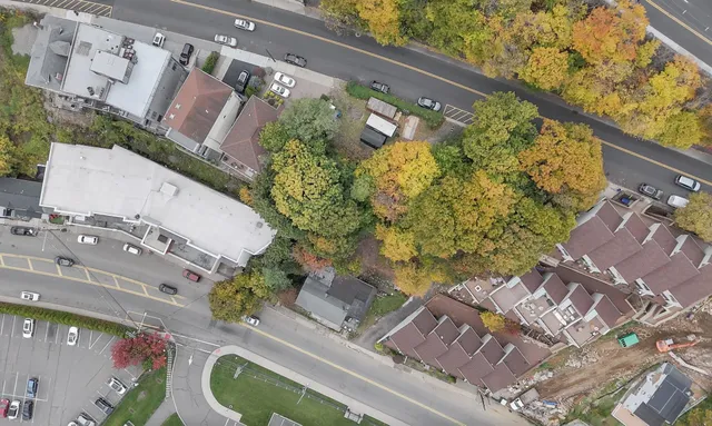 a view of a big house with a big yard and large trees