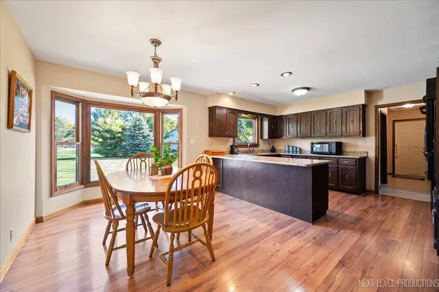 a kitchen with stainless steel appliances granite countertop wooden cabinets a stove a sink and a large window