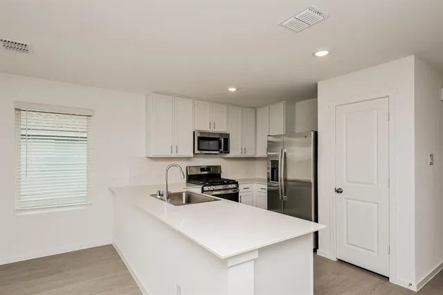 a kitchen with stainless steel appliances a refrigerator sink and microwave