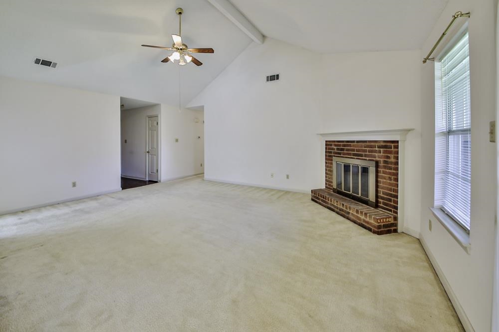 7448 Gingerhill Lane Bartlett, TN 38133 - Photo 15 of 39 an empty room with chandelier fan and windows