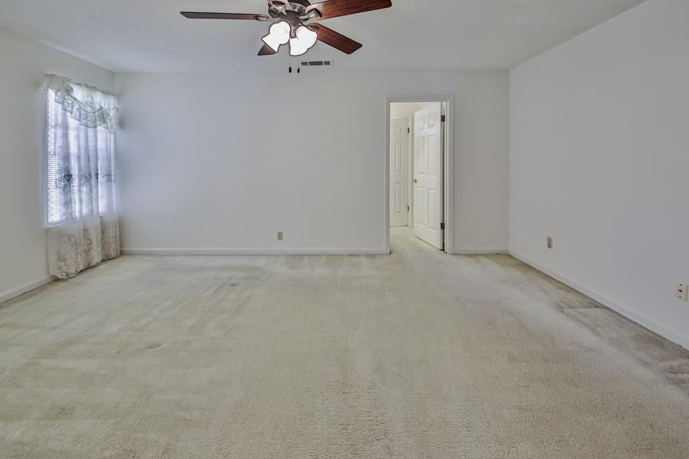 7448 Gingerhill Lane Bartlett, TN 38133 - Photo 17 of 39 en empty room with windows and chandelier fan