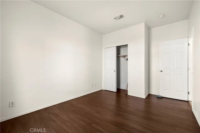 an empty room with wooden floor and closet