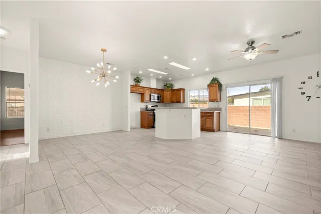 a view of a kitchen with kitchen island stainless steel appliances refrigerator sink and cabinets