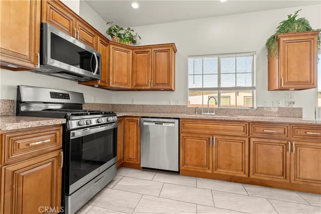 a kitchen with stainless steel appliances granite countertop a stove microwave and sink