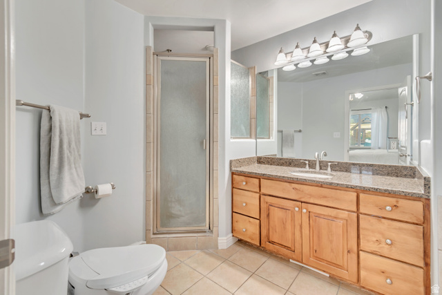 356 North 230 West Payson, UT 84651 - Photo 14 of 45 Bathroom featuring a wood vanity with a granite countertop and integrated sink, a glass-enclosed shower, a large wall-mounted mirror, and tile flooring