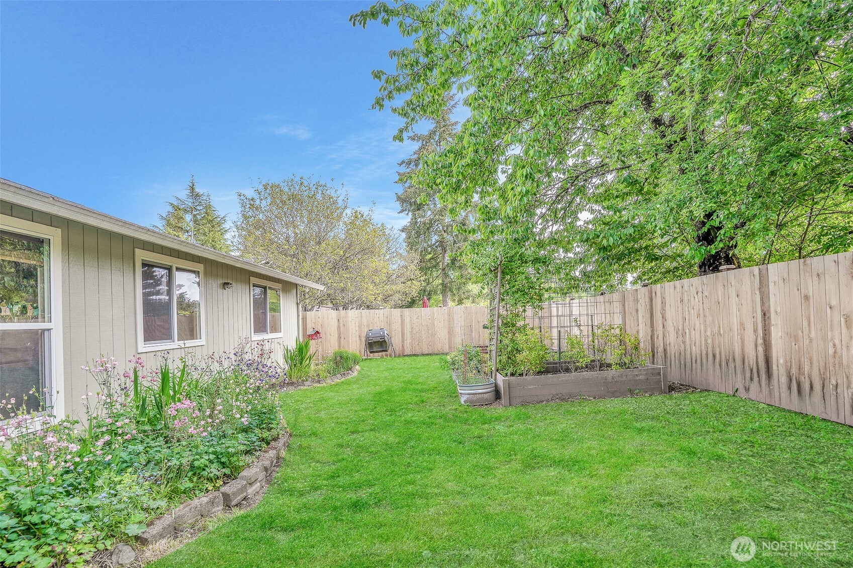 809 Cardigan Street Northwest Olympia, WA 98502 - Photo 27 of 30 a backyard of a house with plants and wooden fence