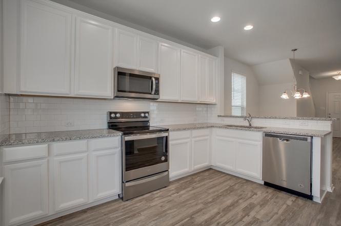 148 Spotted Rail Ridge Leander, TX 78641 - Photo 10 of 31 Culinary delights await in this modern kitchen, featuring stainless steel appliances and ample counter space.