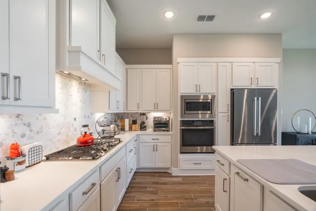 a kitchen with stainless steel appliances a refrigerator sink and cabinets