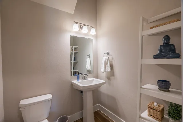 a bathroom with a toilet a sink and mirror